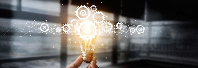 Hand holding a glowing light bulb surrounded by gear icons, a decorative image for research ideas
